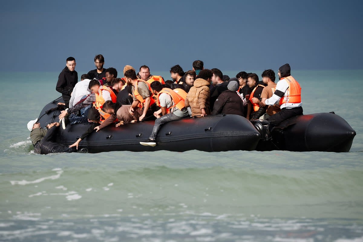 Migrants on an inflatable dinghy attempt to cross the Channel from the Slack dunes in Wimereux, earlier this month (Reuters)