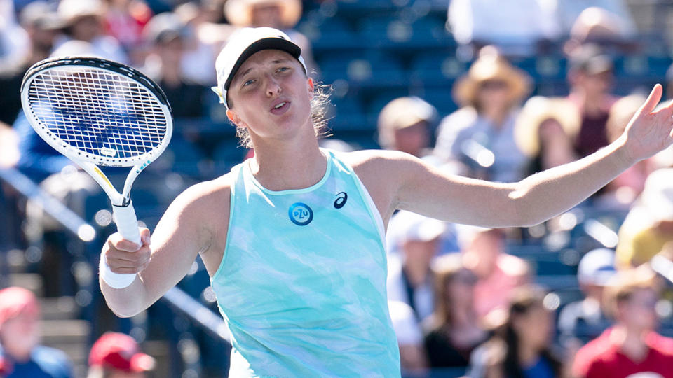 Pictured here, Iga Swiatek throws her arms up in frustration during a match.