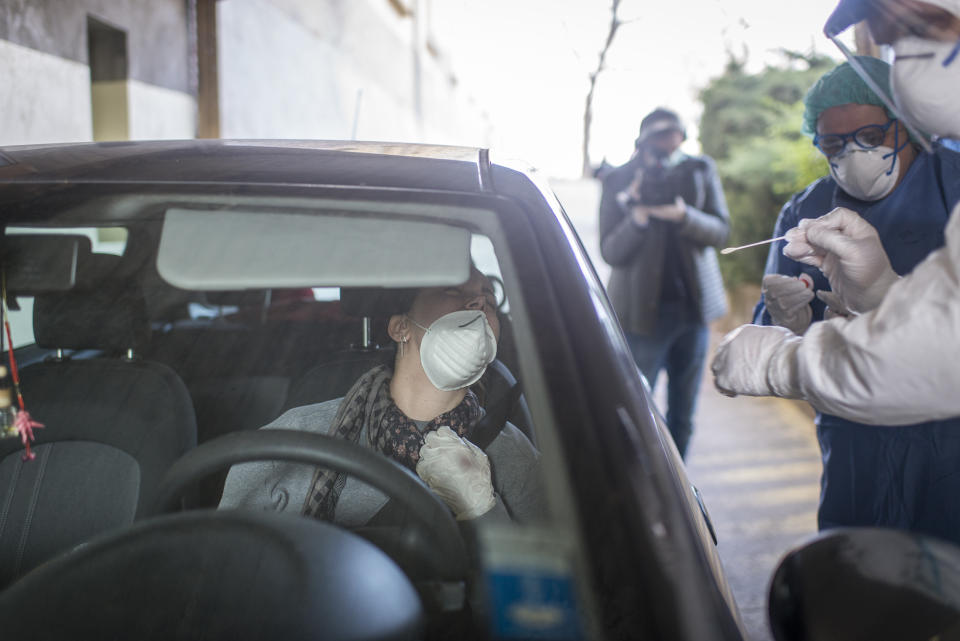 Healthcare workers perform a swab test on woman in her car. Source: AAP