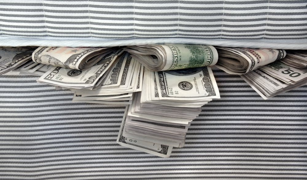 wads of cash stuffed between two mattresses