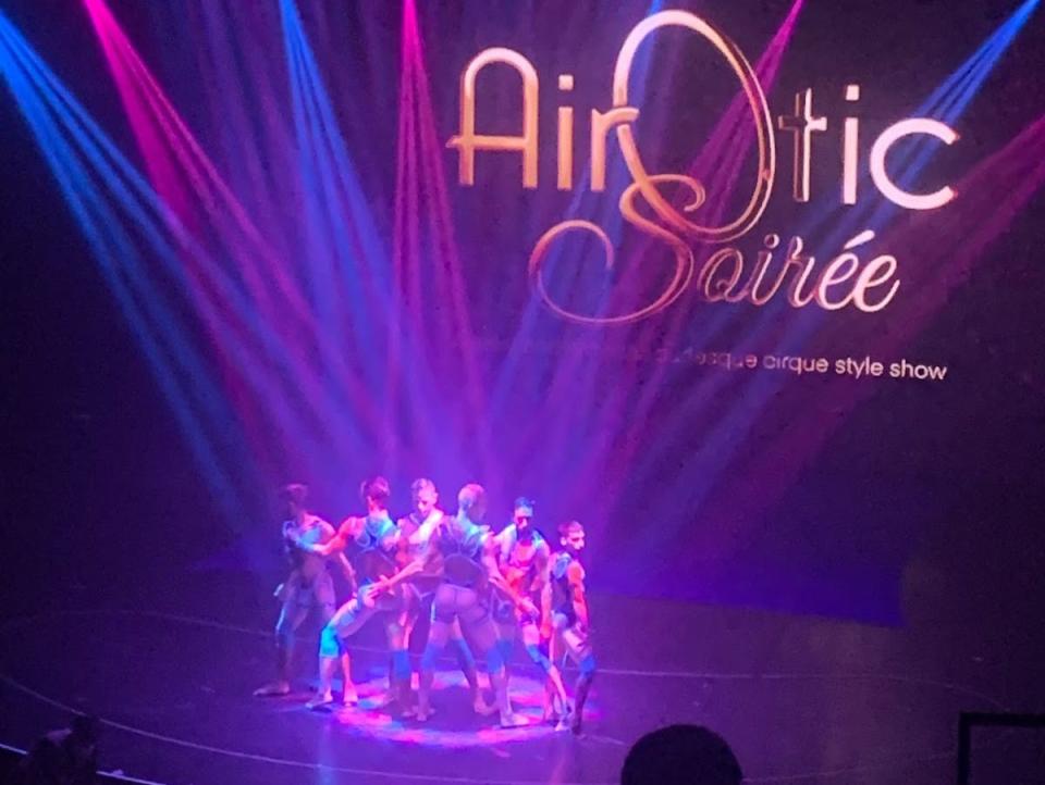 Airotic show with performers on stage under purple lights