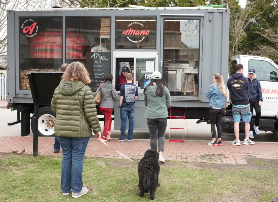 Customers order food from the A Mano pizza truck in Newport.