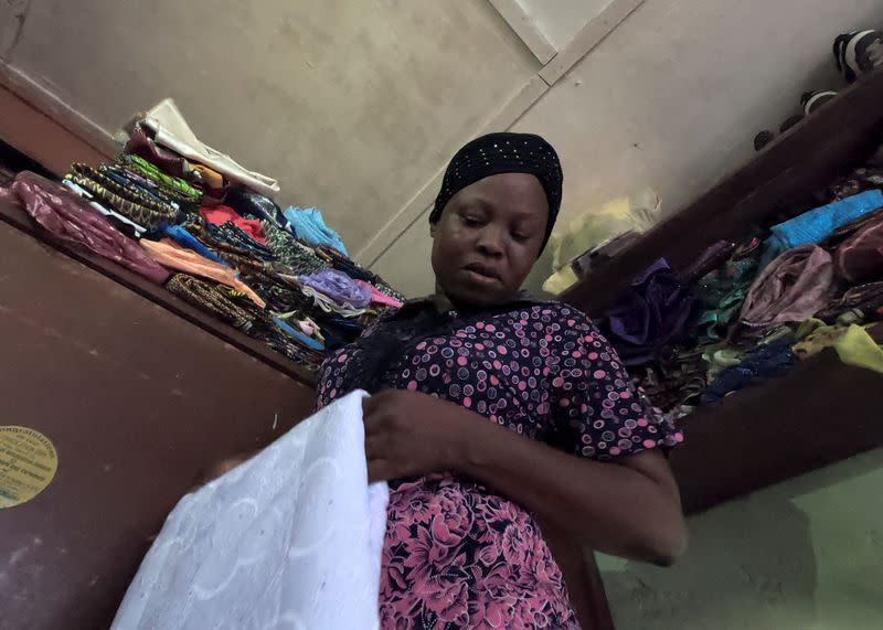 Kemi Adepoju, a dressmaker, folds a material in her shop amid the spread of the coronavirus disease (COVID-19) in Lagos