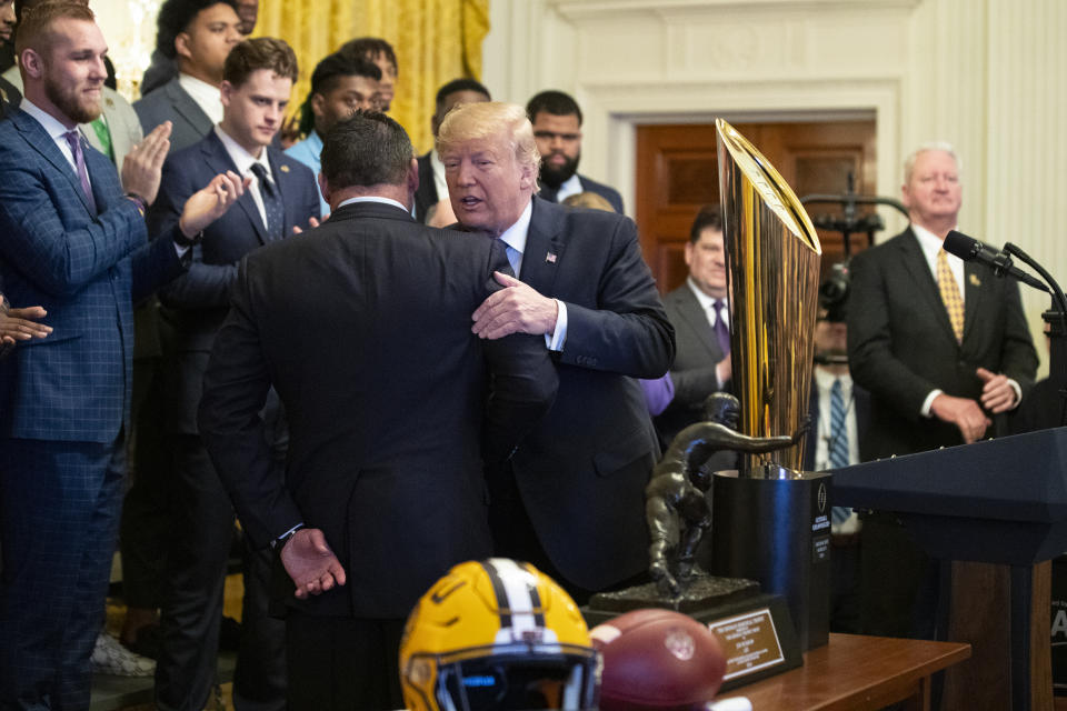 President Donald Trump hugs coach Ed Orgeron during an event to honor the NCAA football national champions, the Louisiana State University Tigers, in the East Room of the White House, Friday, Jan. 17, 2020, in Washington. (AP Photo/ Evan Vucci)