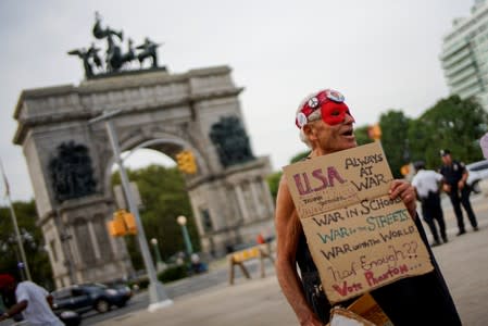 People gather for a vigil to remember victims of the mass shootings at Dayton and El Paso, at Grand Army Plaza in Brooklyn, New York