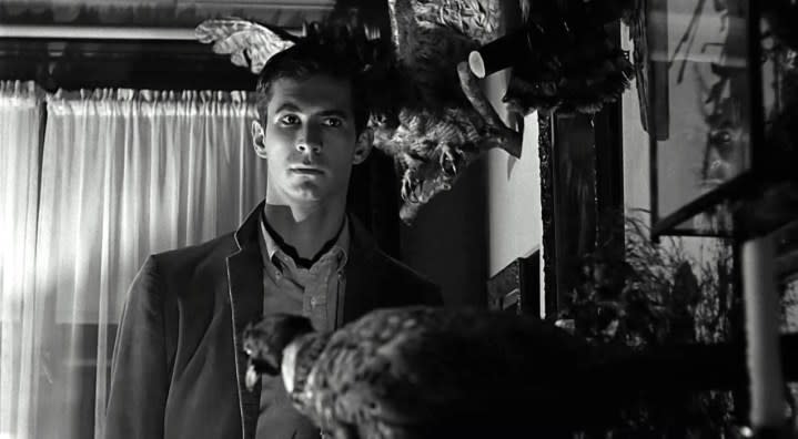 Norman Bates looks ominously at a wall in Psycho.