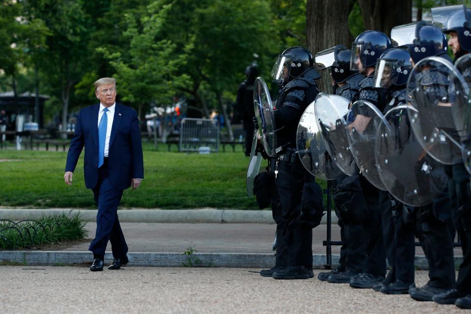 President Donald Trump walks past police in Lafayette Park after visiting outside St. John's Church across from the White House Monday, June 1, 2020, in Washington. Part of the church was set on fire during protests on Sunday night. (AP Photo/Patrick Semansky)