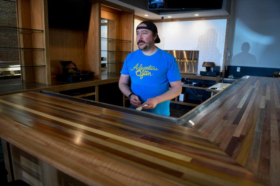 Gilded Goat Brewing Co.'s assistant taproom manager Jed Hutt works behind the bar at the brewery's new location at 132 W. Mountain Ave. in Old Town Fort Collins on Friday.