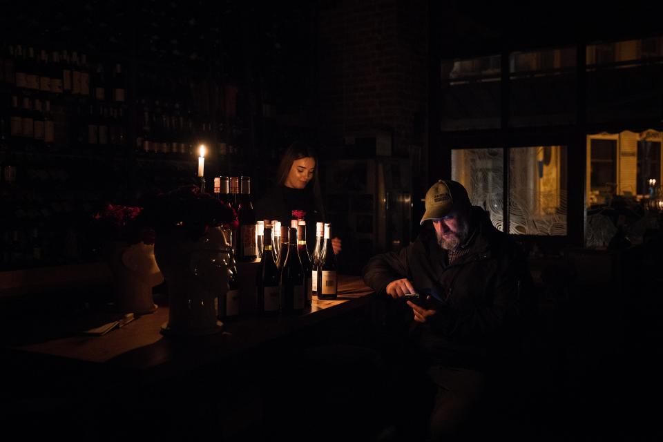 Customers have a meal or a drink by candlelight at the Vinoteca Praha restaurant in the city centre (Getty)