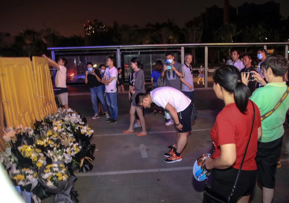 This photo taken on July 26, 2021 shows people placing flowers in front of a subway station as they mourn victims killed in flooding caused by heavy rains in Zhengzhou, China's central Henan province. China OUT
 / AFP / STR