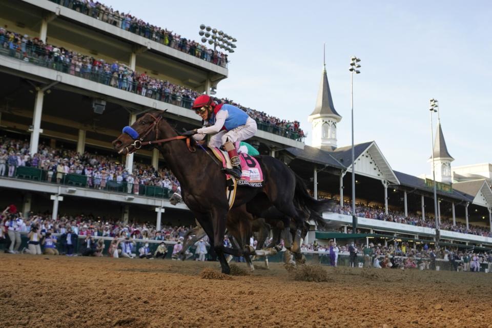 Jockey John Velazquez rides Medina Spirit across the finish line to win the Kentucky Derby.