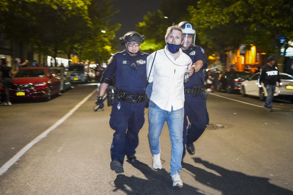HuffPost senior reporter Christopher Mathias is taken into custody after being roughed up while covering the clash between police brutality protesters and New York Police Department officers on Saturday. (Photo: Corey Sipkin/UPI/Newscom)