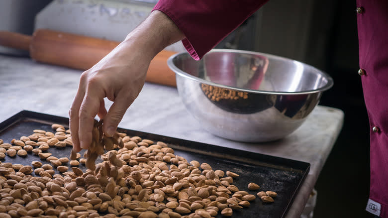 Hand grabbing toasted nuts