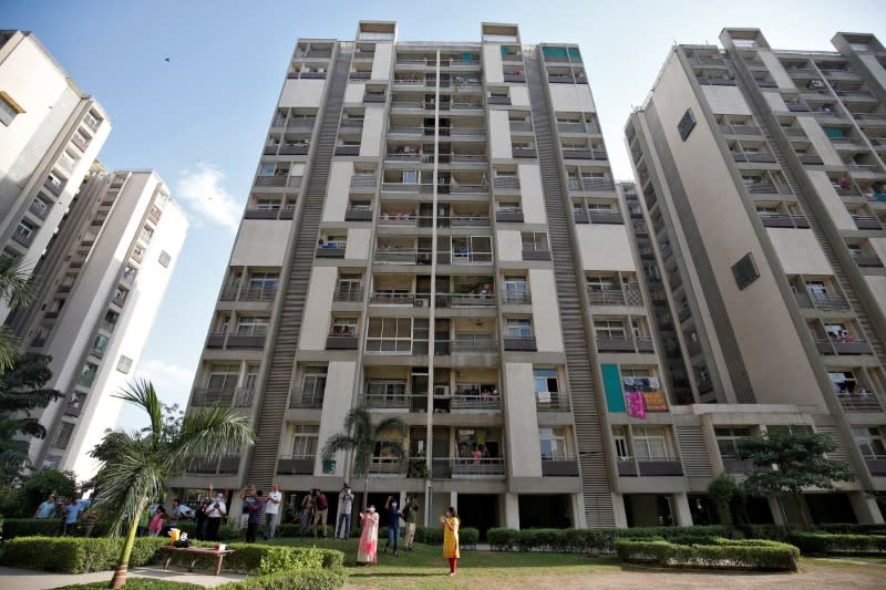 Residents clap and bang utensils to cheer for emergency personnel and sanitation workers who are on the frontlines in the fight against coronavirus, in Ahmedabad