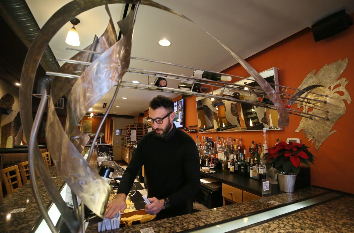Alex White, a bartender at Crave, preps the bar Tuesday for the evening at the Akron eatery.