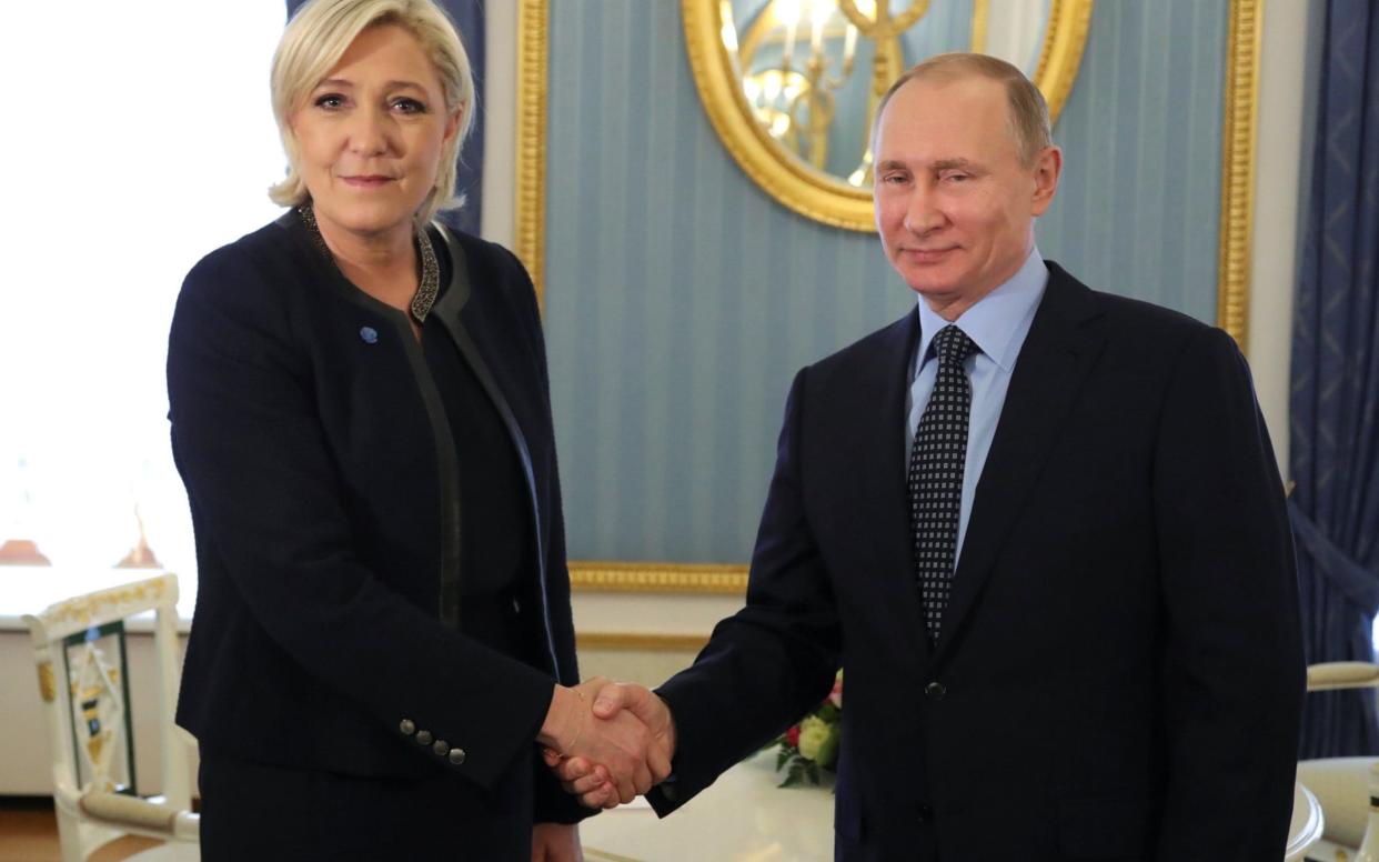 Russian President Putin shakes hands with French far-right party leader Le Pen during their meeting in Moscow - REUTERS