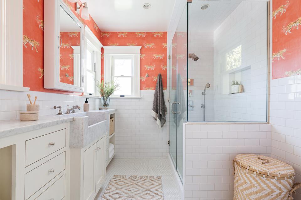 In a bathroom, some of Dunham’s colorful aesthetic remains in the form of orange printed wallpaper.