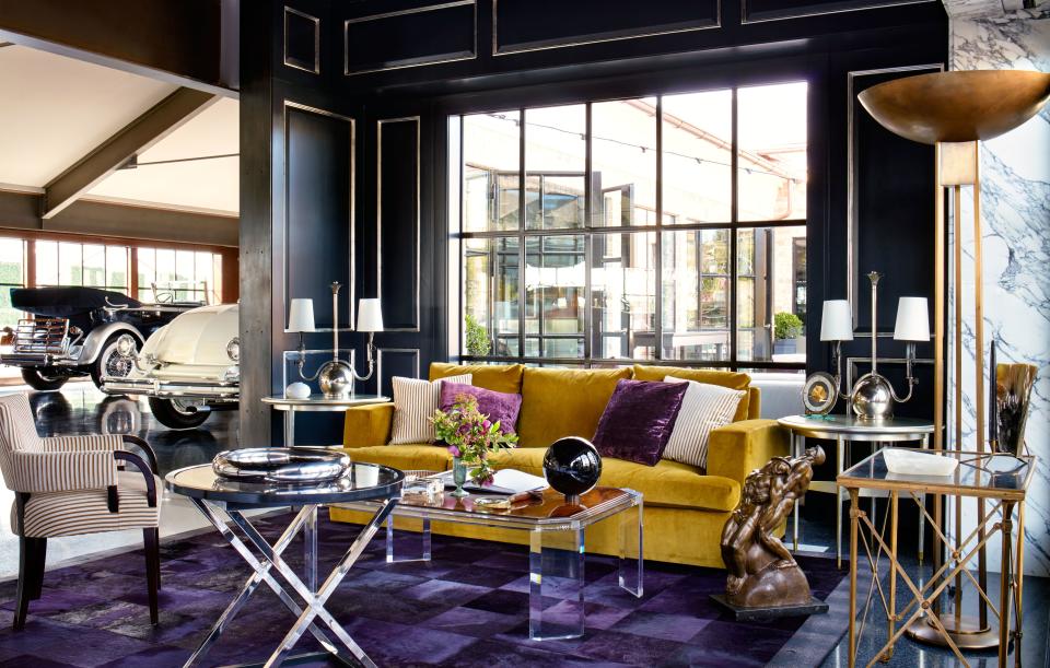 The office sitting area features a Jonas sofa in a Schumacher velvet behind a cocktail table by Thomas O’Brien for Century furniture. The paneling is painted with Farrow & Ball’s Off-Black.