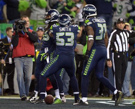 Jan 19, 2014; Seattle, WA, USA; Seattle Seahawks outside linebacker Malcolm Smith (53) celebrates with cornerback Richard Sherman (25) and strong safety Kam Chancellor (31) after intercepting a pass in the end zone in the fourth quater of the 2013 NFC Championship football game against the San Francisco 49ers at CenturyLink Field. Kirby Lee-USA TODAY Sports