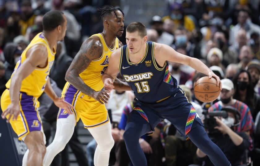 Denver Nuggets center Nikola Jokic, right, works the ball inside as Los Angeles Lakers guard Avery Bradley.