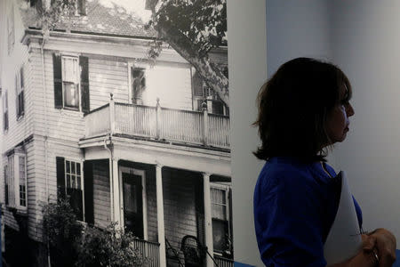 Curator Stacey Bredhoff stands beside a photograph of the home where John F. Kennedy was born, part of the exhibit "JFK 100," marking the 100th anniversary of Kennedy's birth May 29, at the John F. Kennedy Presidential Library in Boston, Massachusetts, U.S., May 19, 2017. REUTERS/Brian Snyder