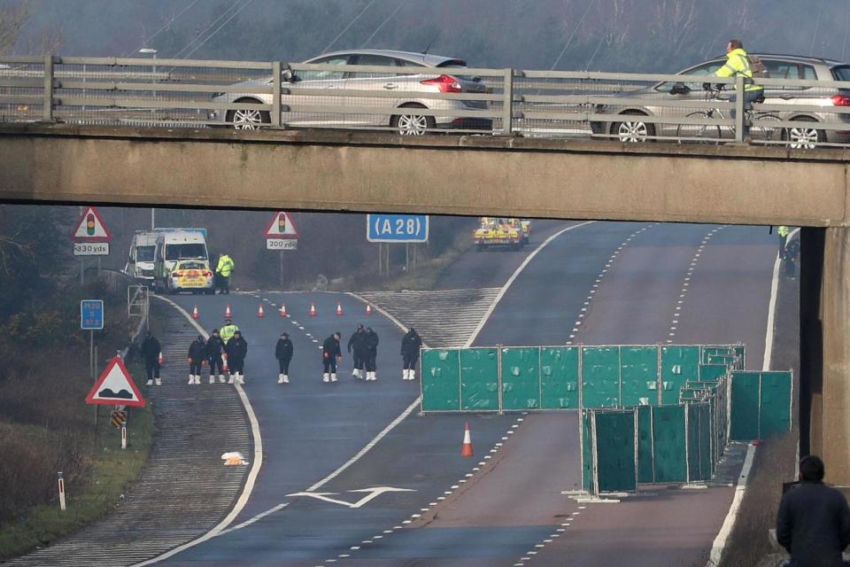 Police officers search by junction 9 on the northbound carriageway of the M20 (PA)
