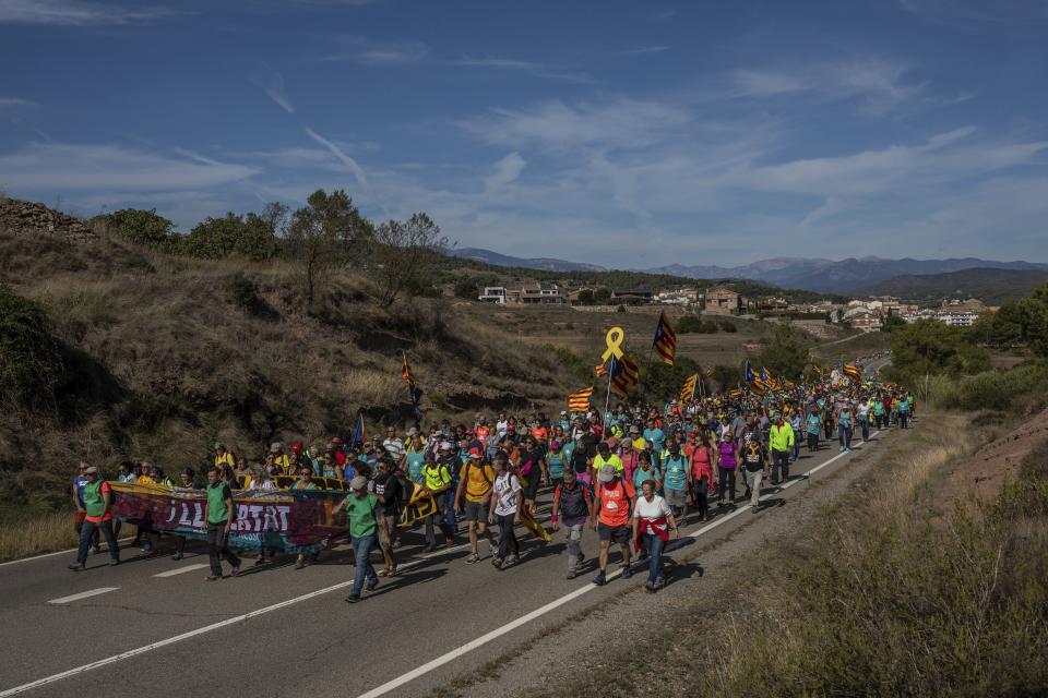 Catalan pro-independence demonstrators march near Navas, Spain, Wednesday, Oct. 16, 2019. Thousands of people have joined five large protest marches across Catalonia that are set to converge on Barcelona, as the restive region reels from two straight days of violent clashes between police and protesters. The marches set off from several Catalan towns and aimed to reach the Catalan capital by Friday. (AP Photo/Bernat Armangue)