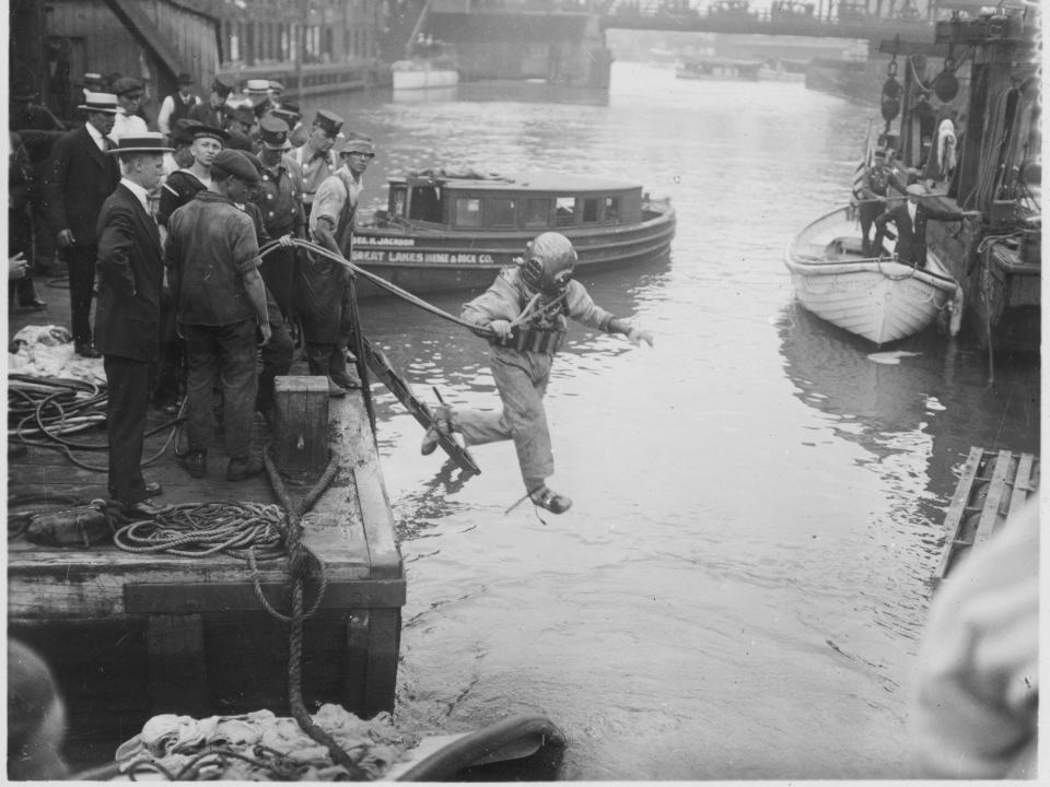 A diver leaps into the water to investigate a crash in 1915.