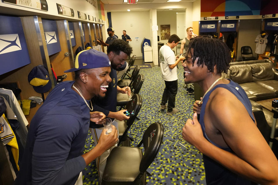 Milwaukee Brewers players Thyago Vieira, left, and Abner Uribe celebrate in the clubhouse after the Brewers beat the Miami Marlins 16-1 in a baseball game and clinching a postseason berth, Friday, Sept. 22, 2023, in Miami. (AP Photo/Wilfredo Lee)