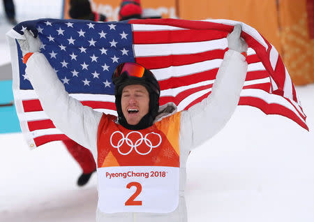 FILE PHOTO: Snowboarding - Pyeongchang 2018 Winter Olympics - Men's Halfpipe Finals - Phoenix Snow Park in Pyeongchang, South Korea - February 14, 2018 - Shaun White of the U.S. celebrates his win as he holds the U.S. flag. REUTERS/Issei Kato/File Photo