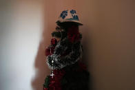 One of the hats sold by street vendor Alika Ogochukwu is seen on a Christmas tree in his house in San Severino Marche, Italy, Friday, Aug. 5, 2022. The brutal killing of a Nigerian immigrant in broad daylight has sparked a debate in this well-to-do Adriatic beach community over whether the attack by an Italian man with a court-documented history of mental illness was racially motivated. It will go to the streets on Saturday, Aug. 6 when a Black Italian activists from all over Italy march through the town demanding justice for Alika Ogorchukwu. (AP Photo/Antonio Calanni)