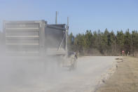 A dump truck departs Arrowhead Landfill generating a cloud of dust, dust on Monday, Feb. 22, 2021, in Uniontown, Ala. Disadvantaged communities in America are disproportionately affected by pollution from industry or waste disposal, but their complaints have few outlets and often reach a dead end. Hundreds of discrimination claims sent to the Environmental Protection Agency’s civil rights office since the mid-90s have only once resulted in a formal finding of discrimination. And some cases languished for years — or decades.(AP Photo/Vasha Hunt)