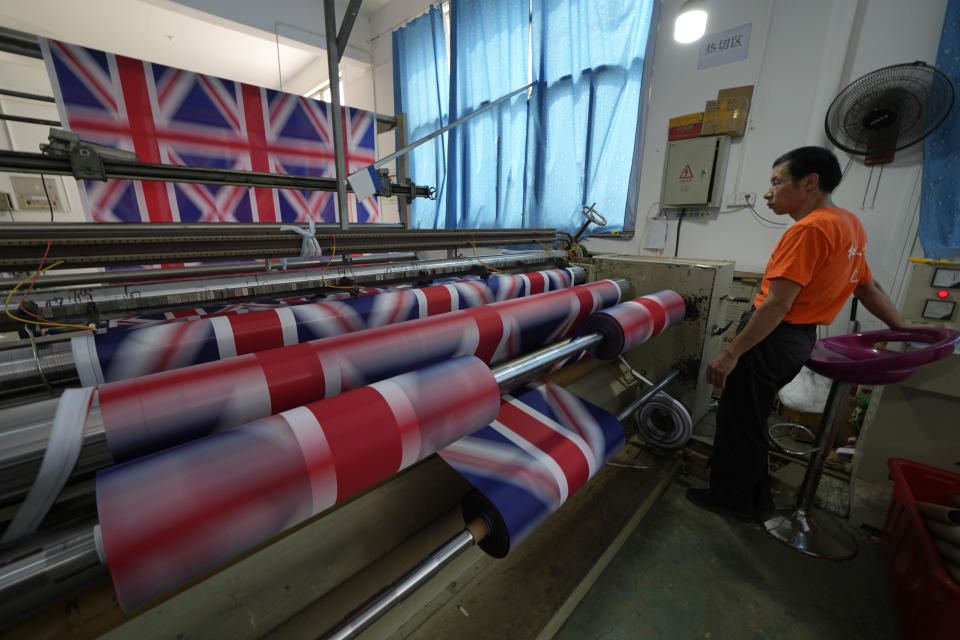 A worker produces British flags at the Shaoxing Chuangdong Tour Articles Co. factory in Shaoxing, in eastern China's Zhejiang province, Friday, Sept. 16, 2022. Ninety minutes after Queen Elizabeth II died, orders for thousands of British flags started to flood into the factory south of Shanghai. (AP Photo/Ng Han Guan)