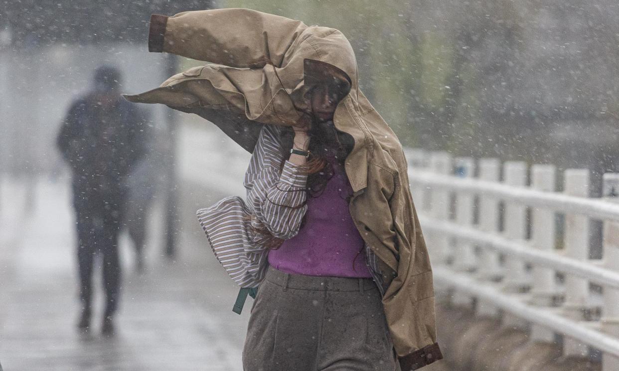 <span>People brave the wind and rain on Waterloo Bridge London on Monday. Bridges and parks across the UK were forced to close due to the conditions.</span><span>Photograph: Alex Lentati/LNP</span>