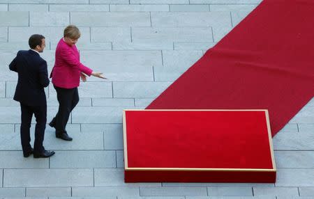 FILE PHOTO: German Chancellor Angela Merkel and French President Emmanuel Macron arrive at a ceremony at the Chancellery in Berlin, Germany, May 15, 2017. REUTERS/Hannibal Hanschke/File Photo