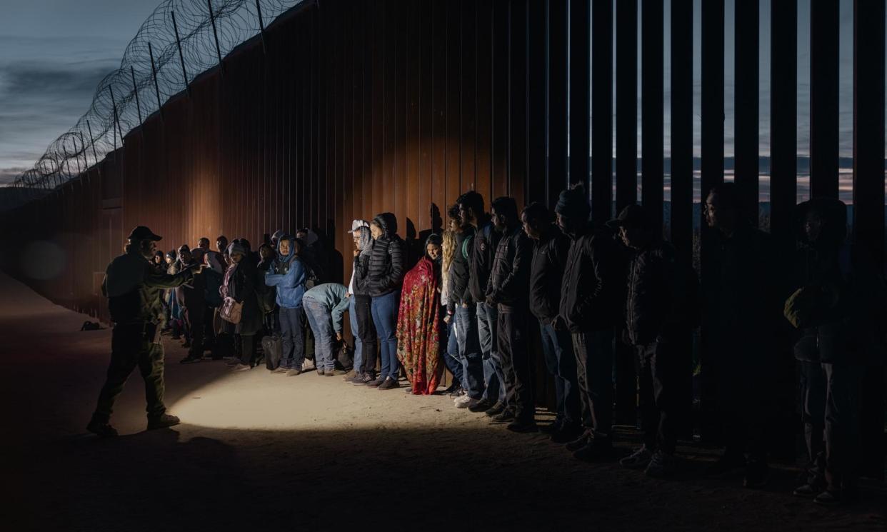 <span>People seeking asylum wait to be processed by US border patrol near Jacumba Hot Springs in San Diego, California, in December 2023.</span><span>Photograph: VCG/Getty Images</span>