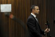 Oscar Pistorius stands in the dock at the high court in Pretoria, South Africa, Wednesday, May 14, 2014. The judge overseeing the murder trial of Pistorius on Wednesday ordered the double-amputee athlete to undergo psychiatric tests, meaning that the trial proceedings will be delayed. The court adjourned until May 21, 2014. (AP Photo/Werner Beukes, Pool)