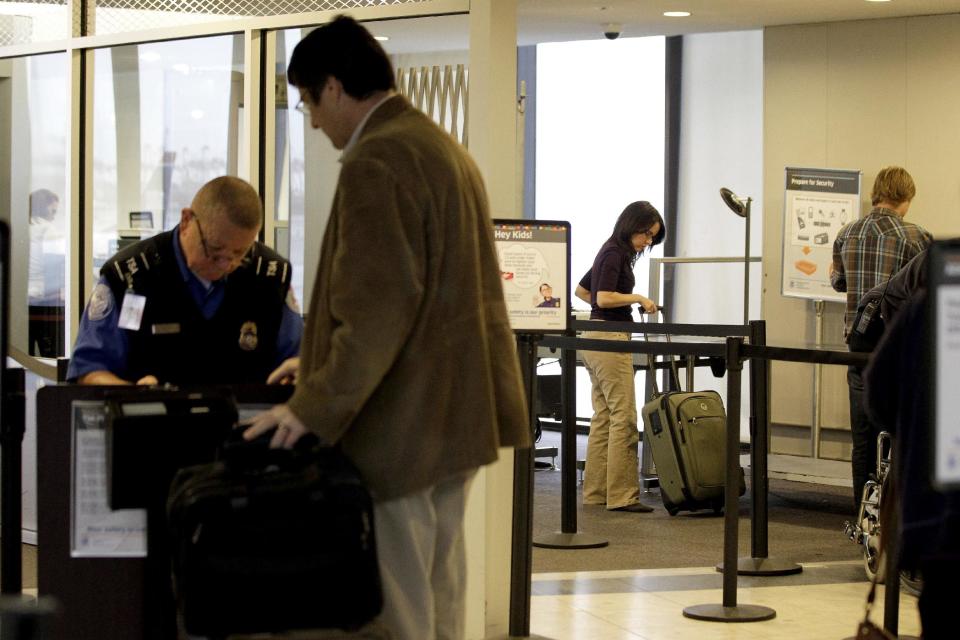 FILE - In this Nov. 17, 2011 photo, travelers move through the security area of Newark Liberty International Airport in Newark, N.J. After a man was arrested at Los Angeles International Airport wearing a bulletproof vest, flame-resistant pants and had a suitcase full of weapons, the TSA has restated what air travelers are allowed to bring along. (AP Photo/Julio Cortez, File)