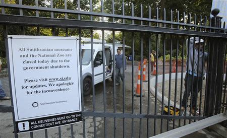 A construction crew works on a project behind the gates of the Smithsonian National Zoo, which is closed due to the government shutdown, in Washington October 2, 2013. REUTERS/Gary Cameron