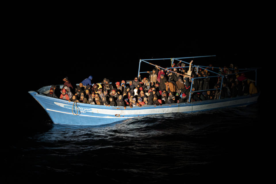 Migrants wait to be rescued off the coast of Lampedusa, Italy, late Monday Jan. 24, 2022. Seven migrants have died and some 280 have been rescued by the Italian Coast Guard after they were discovered in a packed wooden boat off the coast of the Italian island of Lampedusa. (AP Photo/Pau de la Calle)