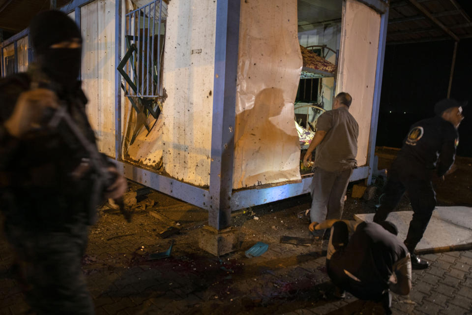 Palestinians check a damaged police container following an explosion targeted a Hamas police checkpoint in Gaza City, Wednesday, Aug. 28, 2019. Hamas officials in the Gaza Strip say two explosions ripped through police checkpoints in Gaza City. (AP Photo/Khalil Hamra)