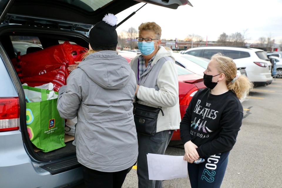 Jeanie Heng, center, of Byron, loads Black Friday purchases into a vehicle on Friday, Nov. 26, 2021, in Rockford. Heng spent the day shopping with her daughter Jennifer Heng, left, and granddaughter Brooke Schulz, both of Leaf River.