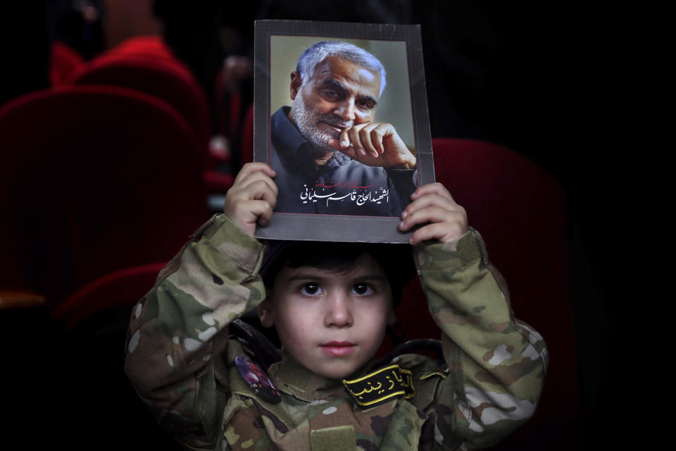 A boy holds up a picture of the head of Iran's Quds force General Qassem Soleimani, who was killed in a U.S. drone strike in Baghdad, during a ceremony to mark the second anniversary of his assassination, in the southern Beirut suburb of Dahiyeh, Lebanon, Monday, Jan. 3, 2022. (AP Photo/Bilal Hussein)