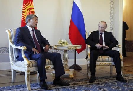 Kyrgyz President Almazbek Atambayev (L) talks to his Russian counterpart Vladimir Putin during their meeting at the Constantine (Konstantinovsky) Palace in St. Petersburg March 16, 2015. REUTERS/Anatoly Maltsev/Pool