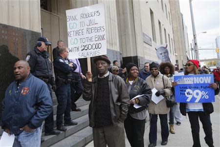 City of Detroit Public Works pensioner Ernest Thomas (C), 79, carries a sign as he protests cuts in city worker pensions in front of the Federal Court House in Detroit, Michigan October 28, 2013. REUTERS/Rebecca Cook