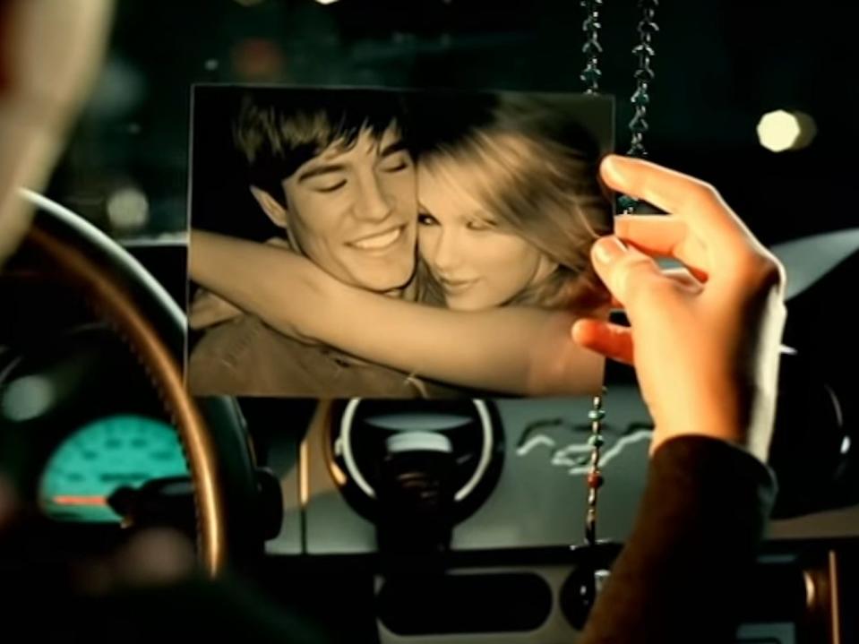 Justin Sandy and Taylor Swift in a photograph in her music video for "Picture to Burn."