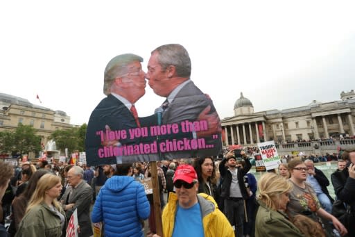 Anti-Trump protesters hold a placard depicting US President Donald Trump (L) and Brexit Party leader Nigel Farage (R)