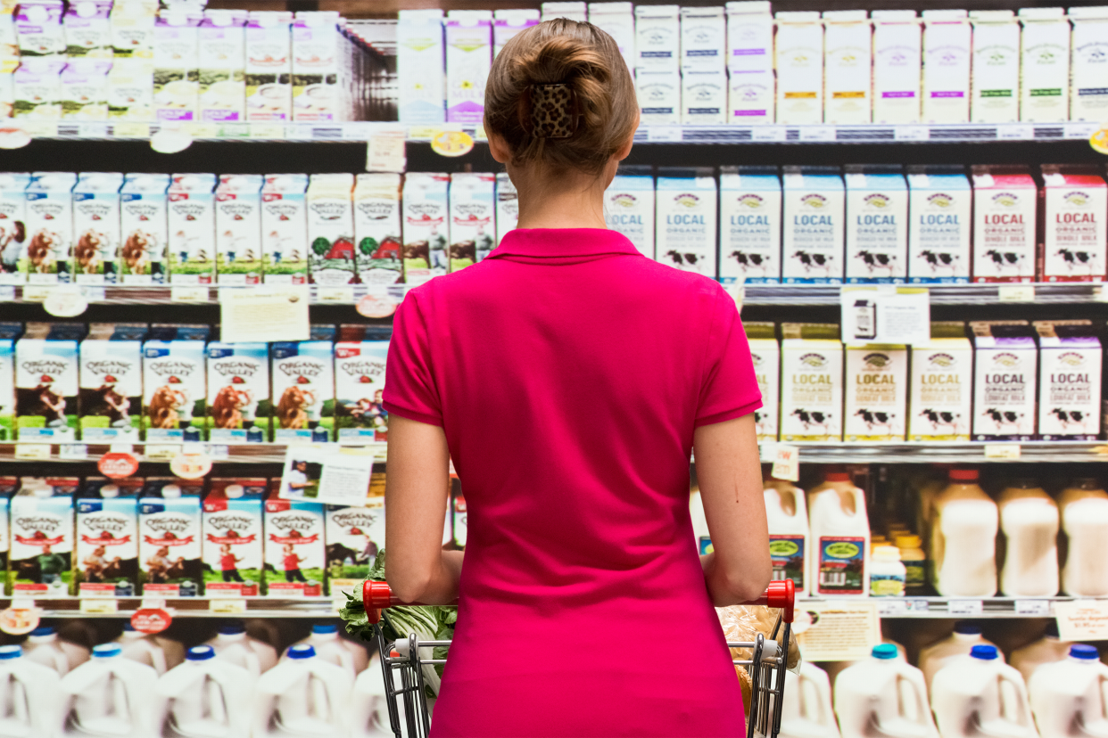 Woman in front of milk at grocery store