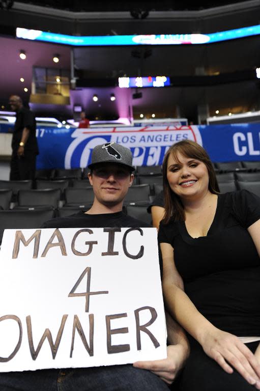 Clippers fans Jonathan and Brittany Brandon hold a sign reading, "Magic 4 Owner" before the start of the NBA playoff game between the Los Angeles Clippers and the Golden State Warriors, April 29, 2014 at Staples Center in Los Angeles, California