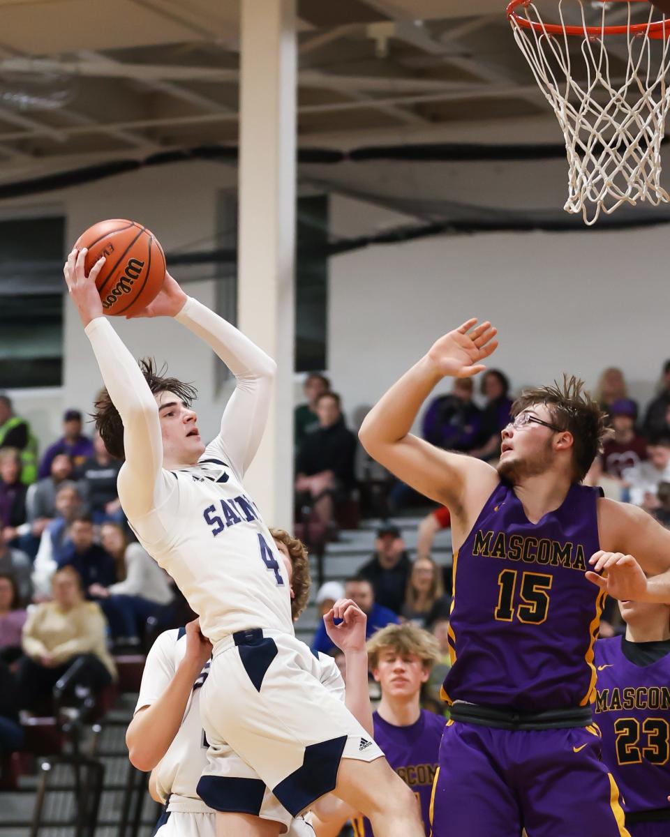 St. Thomas Aquinas' Brady Rogers grabs an offensive rebound as Mascoma's Tyler-Jay Mardin defends during Wednesday's Division III boys basketball semifinal at Goffstown High School.